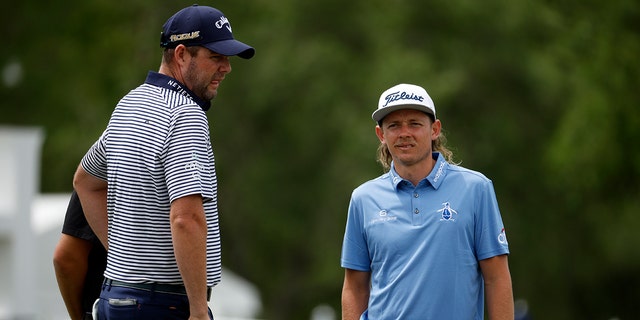 Marc Leishman, left, and Cameron Smith watch the pro-am prior to the Zurich Classic of New Orleans at TPC Louisiana on April 20, 2022 in Avondale, Louisiana.