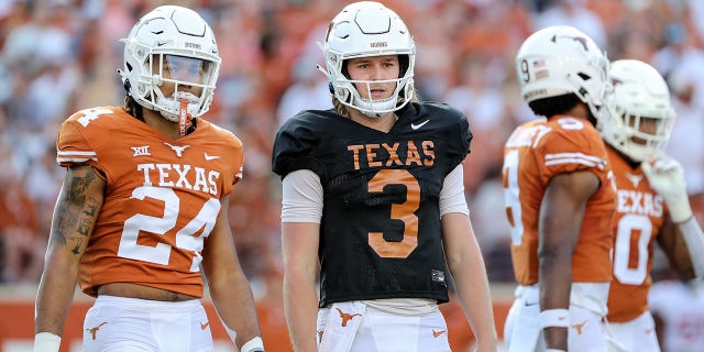Longhorns' Quinn Ewers, center, looks to the sideline for a play at Darrell K Royal-Texas Memorial Stadium on April 23, 2022, in Austin, Texas.
