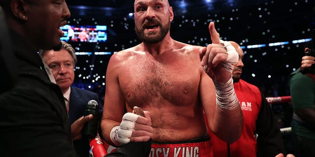 Tyson Fury talks with Dillian Whyte's corner following the WBC World Heavyweight Title Fight at Wembley Stadium on April 23, 2022, in London.
