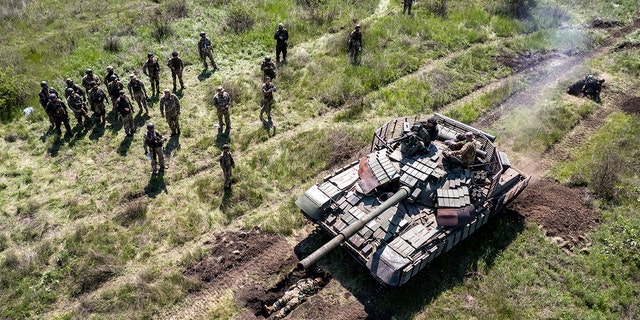Un tanque ucraniano conduce a un soldado de infantería durante un ejercicio cerca de la región de Dnipropetrovsk, Ucrania, el 9 de mayo de 2022.
