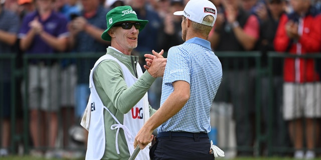 Will Zalatoris and his caddy, Ryan Goble, show camaraderie on the 18th green during the third round of the 122nd U.S. Open Championship at The Country Club on June 18, 2022 in Brookline, Massachusetts.