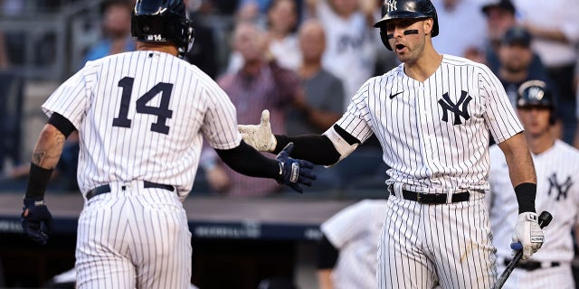 Joey Gallo #13 of the New York Yankees congratulates Marwin Gonzalez #14 of the New York Yankees after hitting a home run during the second inning of the game against the Oakland Athletics at Yankee Stadium on June 28, 2022 in New York City.