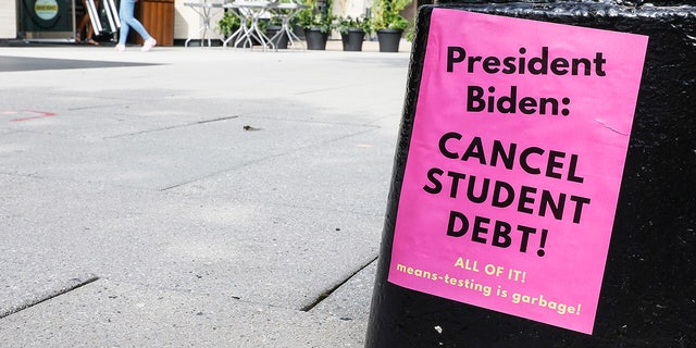 A sign asking President Biden to write off student debt is posted on Pennsylvania Avenue near the White House Staff Entrance during a demonstration demanding President Biden to write off student loan debt on August 27, 2022 at the executive office in Washington, D.C. 