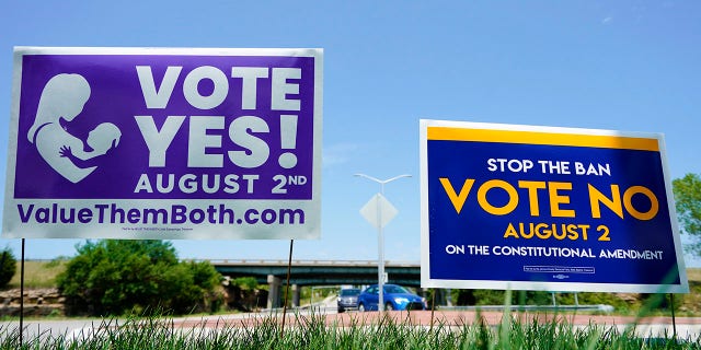 Signs in favor and against the Kansas Constitutional Amendment On Abortion are displayed outside Kansas 10 Highway on Aug. 1, 2022 in Lenexa, Kansas.