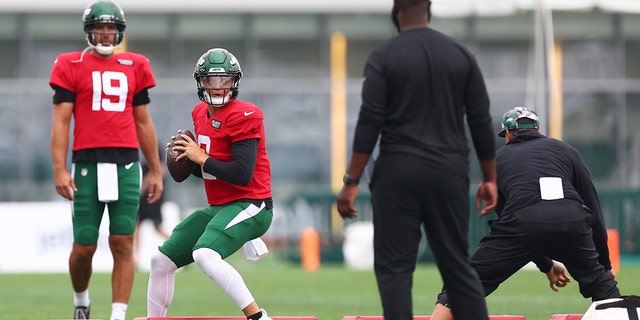 New York Jets quarterback Zach Wilson, No. 2, appears to pass for Joe Flacco, No. 19, looks on during training camp at the Atlantic Health Jets Training Center on August 1, 2022 in Florham Park, New Jersey. 
