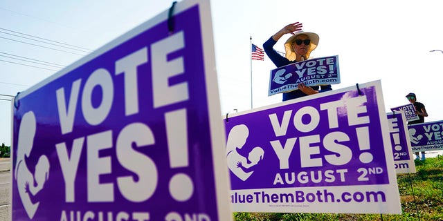 Olathe, KANSAS - AUGUST 01: A supporter of the Vote Yes to a Constitutional Amendment on Abortion holds up a sign along 135th Street on August 01, 2022 in Olathe, Kansas. (Photo by Kyle Rivas/Getty Images)