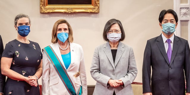 Temsilciler Meclisi Başkanı Nancy Pelosi, merkez sol, Tayvan Devlet Başkanı Tsai Ing-wen'den, merkez sağda, cumhurbaşkanlığı ofisinde Tayvan'ın en yüksek sivil onuru olan Özel Büyük Kordonlu Elverişli Bulutlar Düzeni'ni aldıktan sonra gösteriliyor.