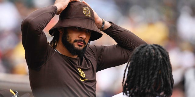 Fernando Tatis Jr. (left) of the San Diego Padres speaks with Josh Bell during a game against the Colorado Rockies at Petco Park in San Diego on August 4, 2022. 