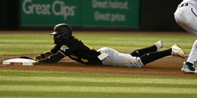 Rodolfo Castro #14 of the Pittsburgh Pirates slides into third base as his cell phone falls out of his pocket during the fourth inning of a game against the Arizona Diamondbacks at Chase Field on August 09, 2022 in Phoenix, Arizona.
