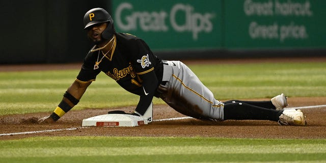 Rodolfo Castro #14 of the Pittsburgh Pirates slides into third base as his cell phone falls out of his pocket during the fourth inning of the game against the Arizona Diamondbacks at Chase Field on August 09, 2022 in Phoenix, Arizona. 