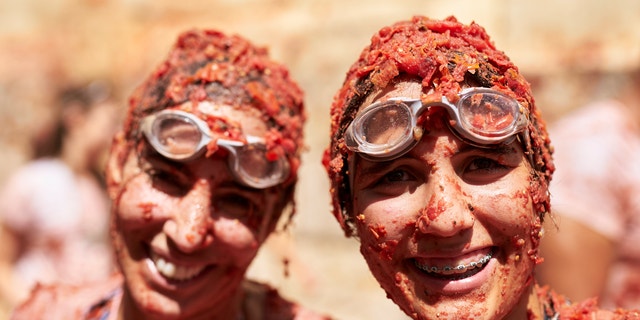 Revelers enjoy the atmosphere in tomato pulp while participating in the annual Tomatina festival in Bunol, Spain, on Wednesday, Aug. 31, 2022.