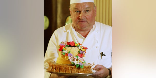 White House pastry chef Roland Mesnier holds up a dessert called Mango Coconut Lei during a preview of the State dinner for Philippines President Gloria Macapagal Arroyo at the State Dining Room of the White House on May 19, 2003.
