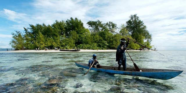 Fishermen paddle off Kennedy Island in the remote Western Province of the Solomon Islands, on July 28, 2003, near where Kennedy's patrol boat PT-109 was rammed by a Japanese destroyer in Aug. 2, 1943. 