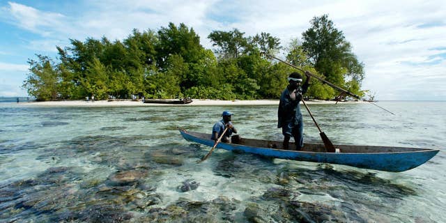 Fishermen paddle off Kennedy Island in the remote Western Province of the Solomon Islands, on July 28, 2003, near where Kennedy's patrol boat PT-109 was rammed by a Japanese destroyer in Aug. 2, 1943.