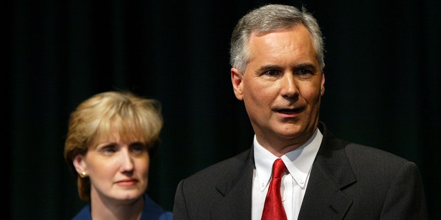 Tom McClintock speaks to reporters with his wife Lori at California State University, Sacramento, on Sept.  24, 2003.