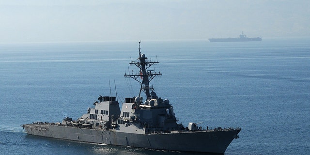The guided-missile destroyer USS Higgins, foreground, and Nimitz-class aircraft carrier USS Carl Vinson arrive off the coast of Haiti.
