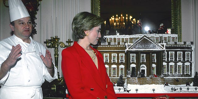 French-born American executive pastry chef Roland Mesnier and then-first lady Hillary Clinton pose with the White House Christmas gingerbread house, Washington, D.C., on Dec. 6, 1993. 