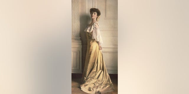 Alice Roosevelt, the eldest daughter of President Theodore Roosevelt, poses for a colorized portrait in a yellow dress.