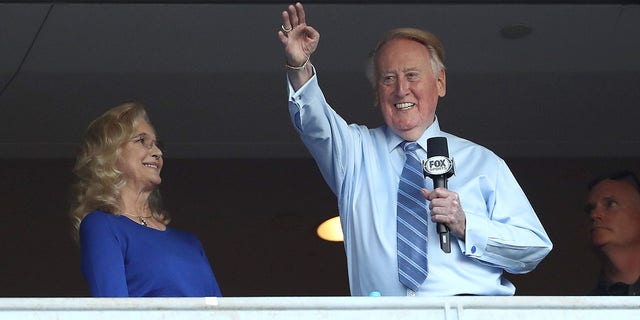 Vin Scully waves to the crowd alongside his wife Sandra Hunt before game five of the National League Division Series against the Chicago Cubs at Dodger Stadium on Oct. 20, 2016, in Los Angeles, California.