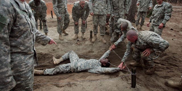 Shalish Grant, 21, of Jersey City, New Jersey is helped through an obstacle course during Army basic training at Fort Jackson.