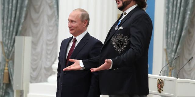 Russian President Vladimir Putin (L) poses with Russian pop singer Philip Kirkorov during a state awards ceremony in the Moscow Kremlin on November 15, 2017.