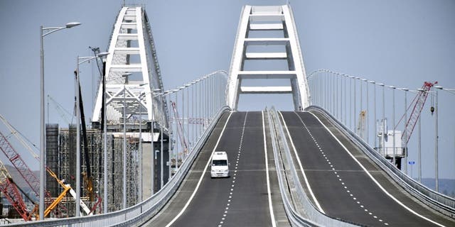 FILE - A vehicle runs down the road-and-rail Crimean Bridge passing over the Kerch Strait and linking southern Russia to the Crimean peninsula on May 15, 2018, in Kerch, prior to the opening ceremony. 