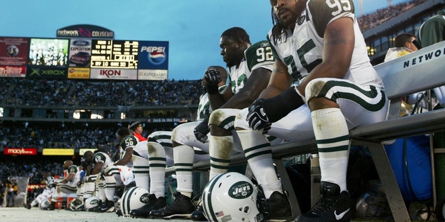 Steve White (95), Shaun Ellis (92) and the rest of the New York Jets' defense look dejected as they sit on the bench in the closing minutes of the AFC divisional playoff game against the Oakland Raiders at Network Associates Coliseum. The Raiders beat the Jets, 30-10. 