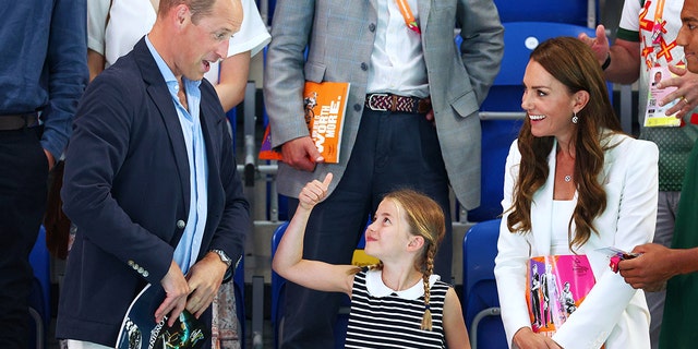 Princess Charlotte gave her proud papa a royal thumbs up.