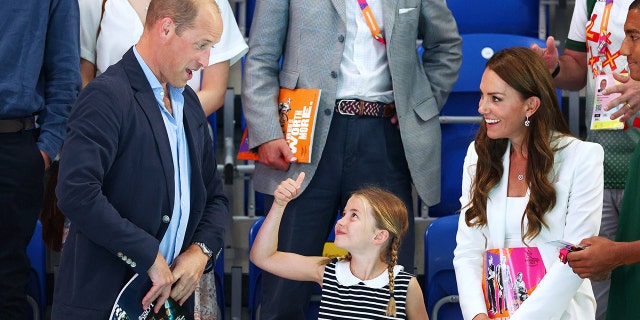 Princess Charlotte gave her proud papa a royal thumbs up.