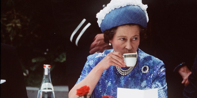 Queen Elizabeth ll has a cup of tea while in Northern Ireland on a royal visit in 1977.