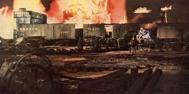 In "Gone with the Wind," the hero and heroine drive through the burning city of Atlanta in a dramatic scene from the MGM film.