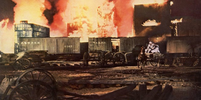 In "Gone with the Wind," the hero and heroine drive through the burning city of Atlanta in a dramatic scene from the MGM film.