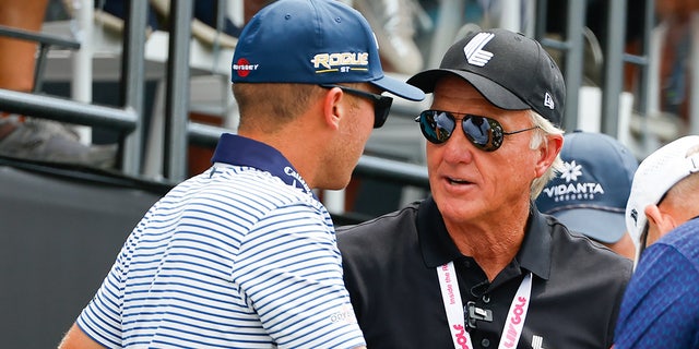 Greg Norman, CEO/commissioner of LIV Golf, right, and Talor Gooch talk at the first tee during the third round of the LIV Golf Invitational Series Bedminster on July 31, 2022, at Trump National Golf Club in Bedminster, New Jersey.