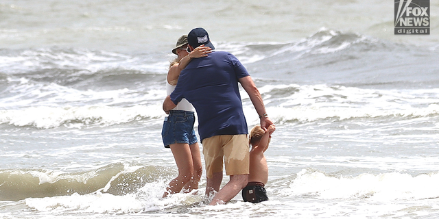 Hunter Biden embraces his wife, Melissa Cohens, as their son Beau plays in the ocean