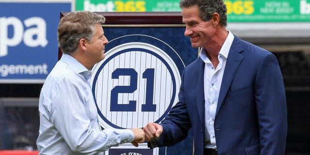 Former New York Yankees player Paul O'Neill fists owner Hal Steinbrenner at a ceremony to retire his number before the game between the New York Yankees and Toronto Blue Jays at Yankee Stadium on August 21, 2022 in New York City.