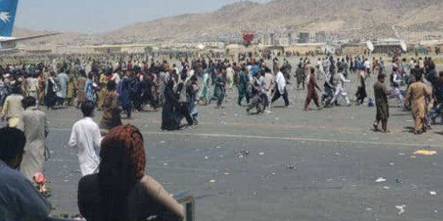 Afghans flood the tarmac of the airport