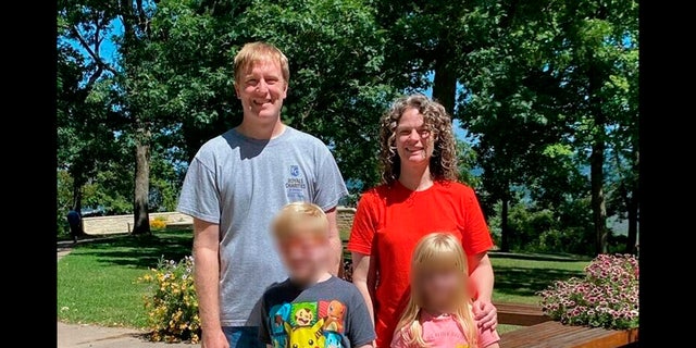 In this undated file photo provided by the Schmidt and Morehead families, Tyler Schmidt and his wife Sarah pose with their children, whose faces have been blurred during a family outing. 