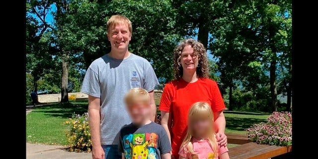 In this undated file photo provided by the Schmidt and Morehead families, Tyler Schmidt and his wife Sarah pose with their children, whose faces have been blurred during a family outing.