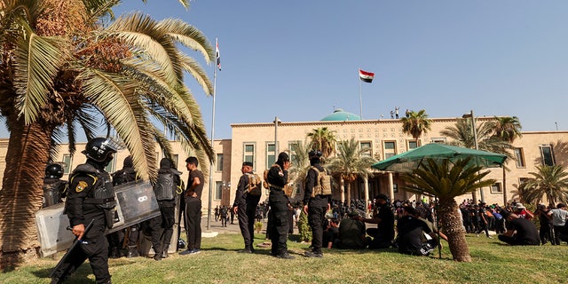 Veiligheidstroepen bewaken protesten van Muqtada al-Sadr-aanhangers bij het Republikeinse Paleis in de Groene Zone, in Bagdad, Irak, 29 augustus 2022.