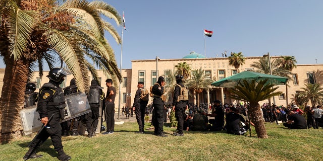 Veiligheidstroepen bewaken protesten van Muqtada al-Sadr-aanhangers bij het Republikeinse Paleis in de Groene Zone, in Bagdad, Irak, 29 augustus 2022.