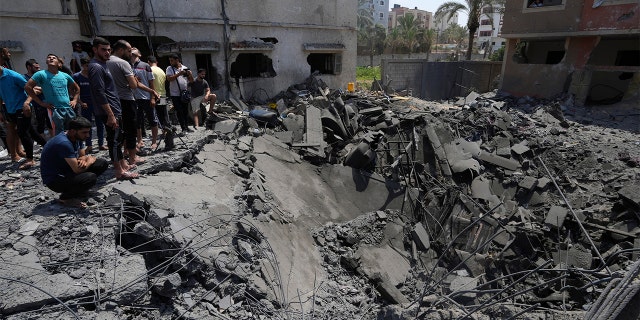 Residents inspect the rubble of destroyed residential building which was hit by Israeli airstrikes, in Gaza, Saturday, Aug. 6, 2022. 