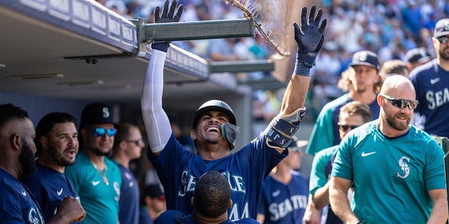 Seattle Mariners' Julio Rodriguez is congratulated by Carlos Santana in the dugout after hitting a solo home run during the eighth inning of a baseball game against the Washington Nationals, Wednesday, Aug. 24, 2022, in Seattle.