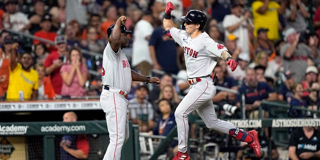Boston Red Sox's Jarren Duran, right, celebrates with third base coach Carlos Febles after hitting a two-run home run against the Houston Astros during the fifth inning of a baseball game Monday, Aug. 1, 2022, in Houston. 