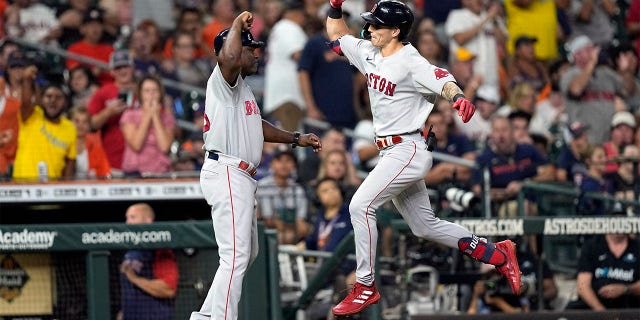 Boston Red Sox's Jarren Duran, right, celebrates with third base coach Carlos Febles after hitting a two-run home run against the Houston Astros during the fifth inning of a baseball game Monday, Aug. 1, 2022, in Houston.