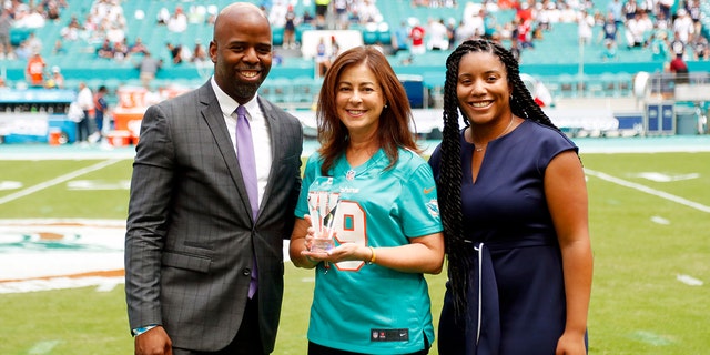 Dolphins senior vice president Jason Jenkins poses with Maria C. Alonzo, center, as part of the NFL's Hispanic Heritage Leaderships Awards ceremony, Sept. 15, 2019, in Miami Gardens, Florida.