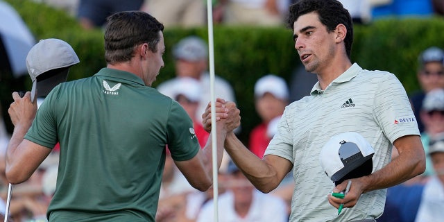 Matt Fitzpatrick, of England, left, speaks with Joaquin Niemann, of Chile, on the 18th green during the second round of the Tour Championship golf tournament at East Lake Golf Club, Friday, Aug. 26, 2022, in Atlanta.