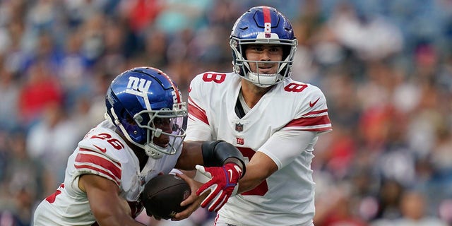 New York Giants quarterback Daniel Jones (8) hands off to running back Saquon Barkley (26) during the preseason game against the New England Patriots on Aug. 11, 2022, in Foxborough, Mass.