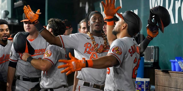 Baltimore Orioles shortstop Jorge Mateo, center, and Anthony Santander, right, celebrate in the dugout after Mateo hit a two-run home run in the ninth inning of a baseball game against the Texas Rangers, Tuesday, Aug. 2, 2022, in Arlington, Texas. The shot also scored Terrin Vavra.