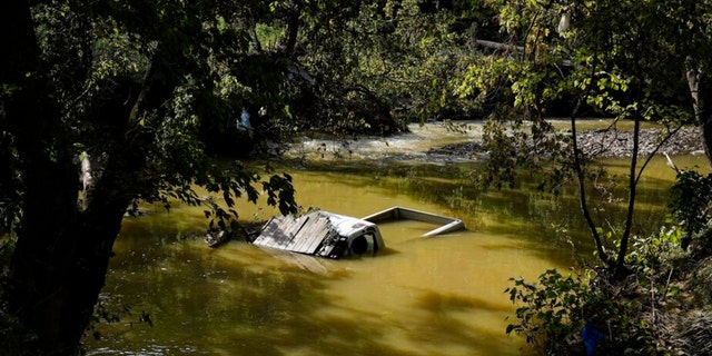 A truck is sunk in water after massive flooding in Hindman, Ky., Aug. 2, 2022.