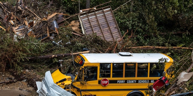 A Perry County school bus, along with other debris, sits in a creek near Jackson, Kentucky, on July 31, 2022. - Rescuers in Kentucky are taking the search effort door-to-door in worsening weather conditions as they brace for a long and grueling effort to locate victims of flooding that devastated the state's east, its governor said on July 31, 2022. 